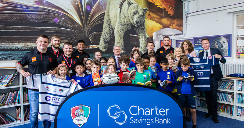 Picture Of rugby club and children holding charter savings bank banners