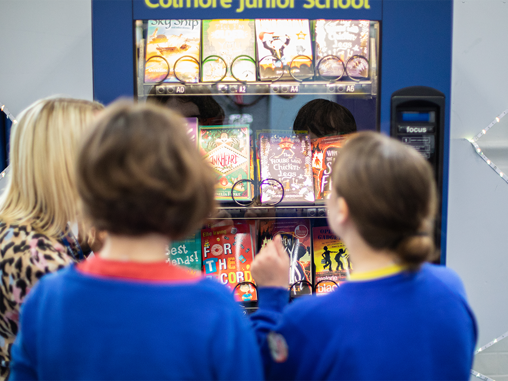 Colmore school children looking at a book shelf with childrens books charter savings bank